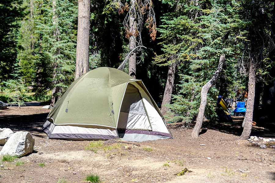 Green tent in the forest at Summit Lake South Campground in Lassen Volcanic National Park, California