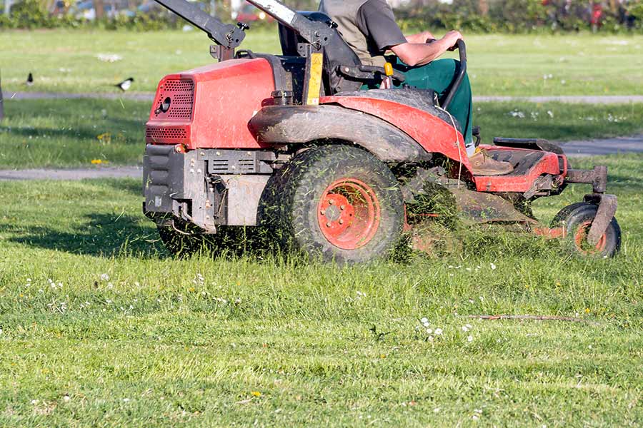 Man mowing campground grass with a zero turn mower