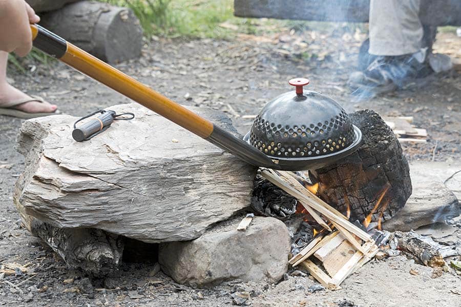 Popping popcorn over campfire