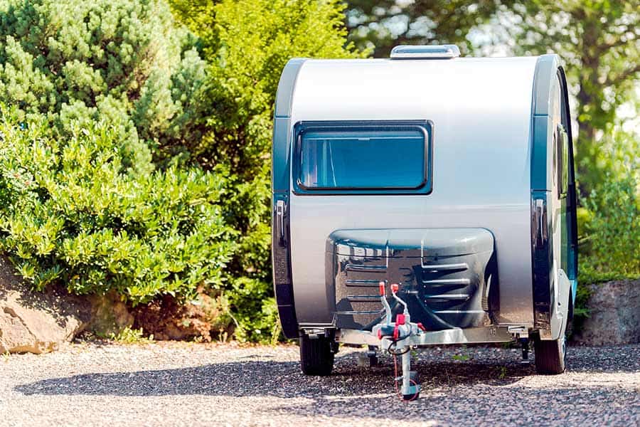 Small camper trailer sitting in driveway