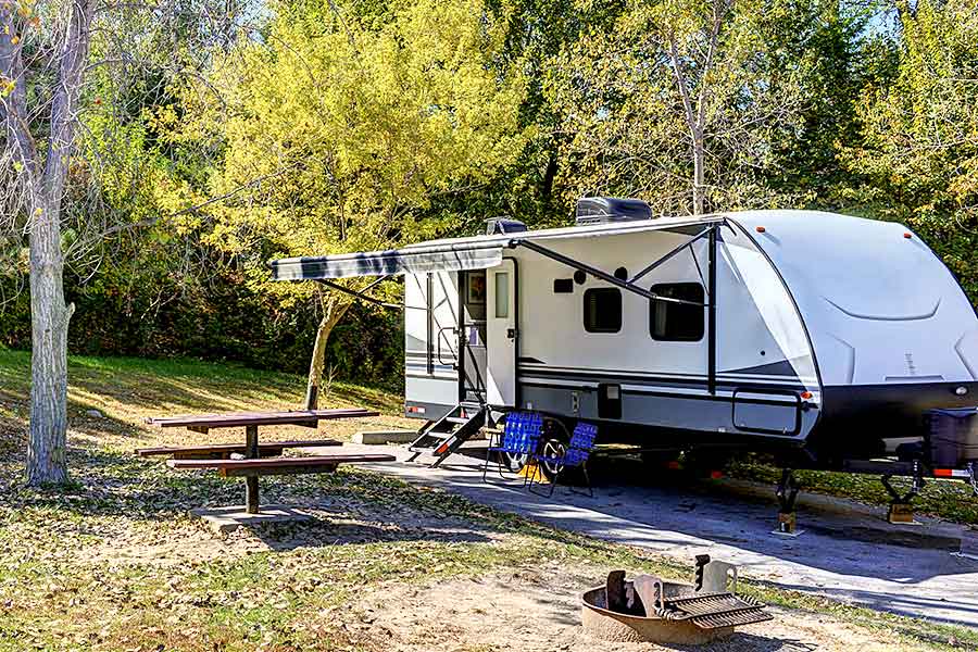 Travel trailer parked at forested campground 