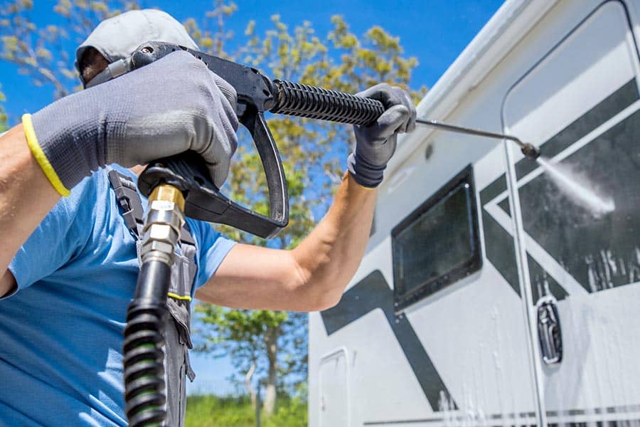 Man power washing camper trailer